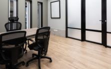 Clean modern office meeting room with chairs and wooden floor